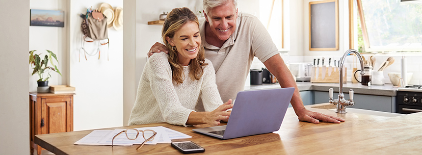 Couple in kitchen using online banking